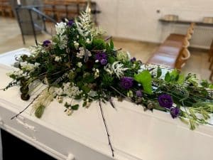 Blomster på hvid kiste