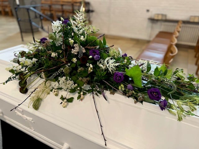 Blomster på hvid kiste
