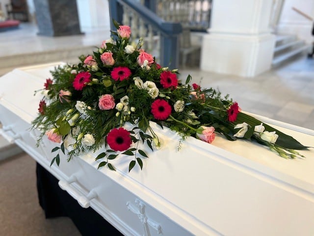 Blomster på hvid kiste