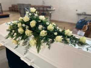 Blomster på hvid kiste