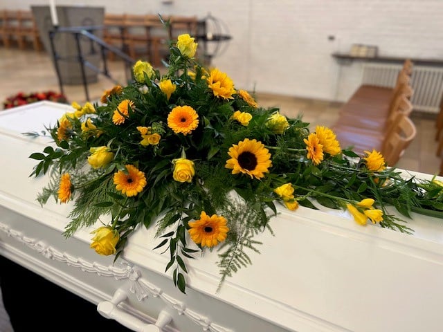 Blomster på hvid kiste